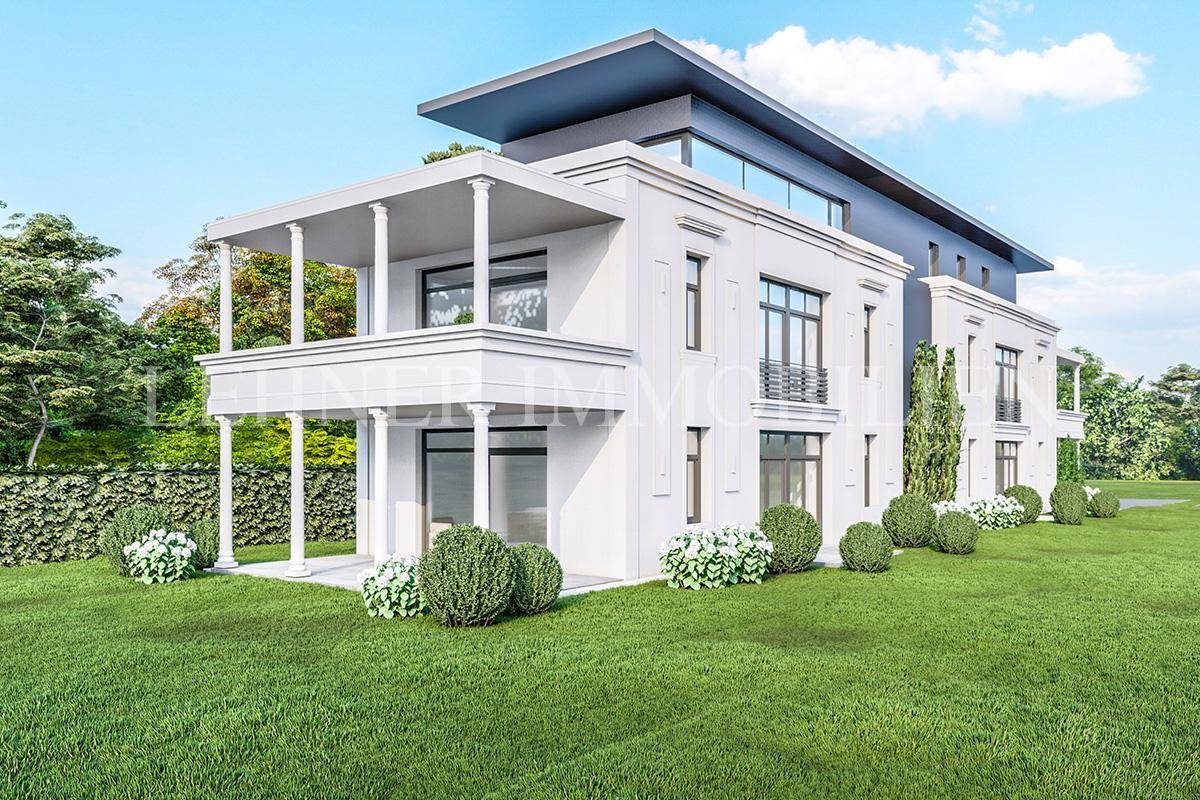 Eine moderne Villa mit klassizistischen Elementen und großem Rasenbereich unter blauem Himmel.