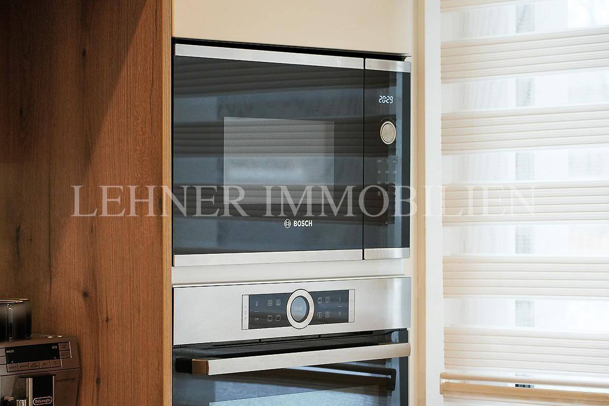 Hochwertige Bosch-Einbaugeräte, darunter Mikrowelle und Backofen, in einer modernen Küche.