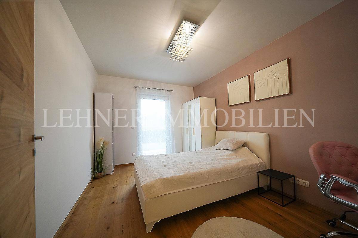Helles Schlafzimmer mit Holzboden, Einzelbett und einem weißen Kleiderschrank.