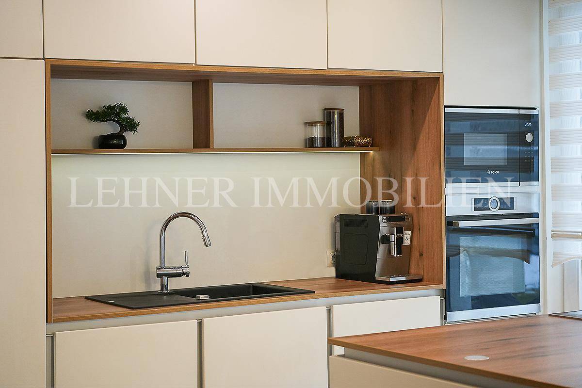 Detailansicht der modernen Küche mit integriertem Backofen, Mikrowelle und Kaffeemaschine.