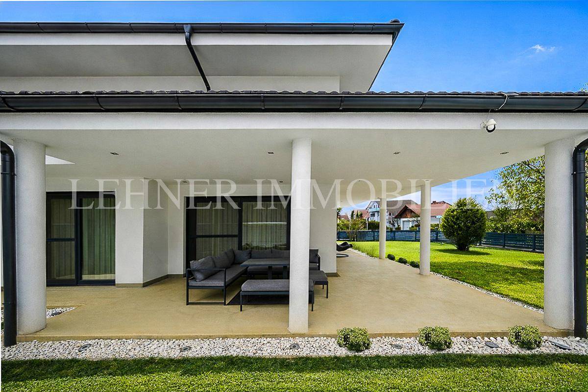 Überdachte Terrasse mit integrierten Lichtern und bequemen Lounge-Möbeln im Freien.