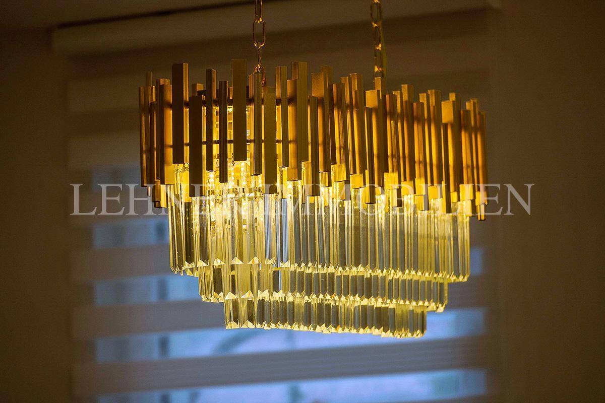 Detailaufnahme eines modernen Kronleuchters mit goldenen und transparenten Elementen.