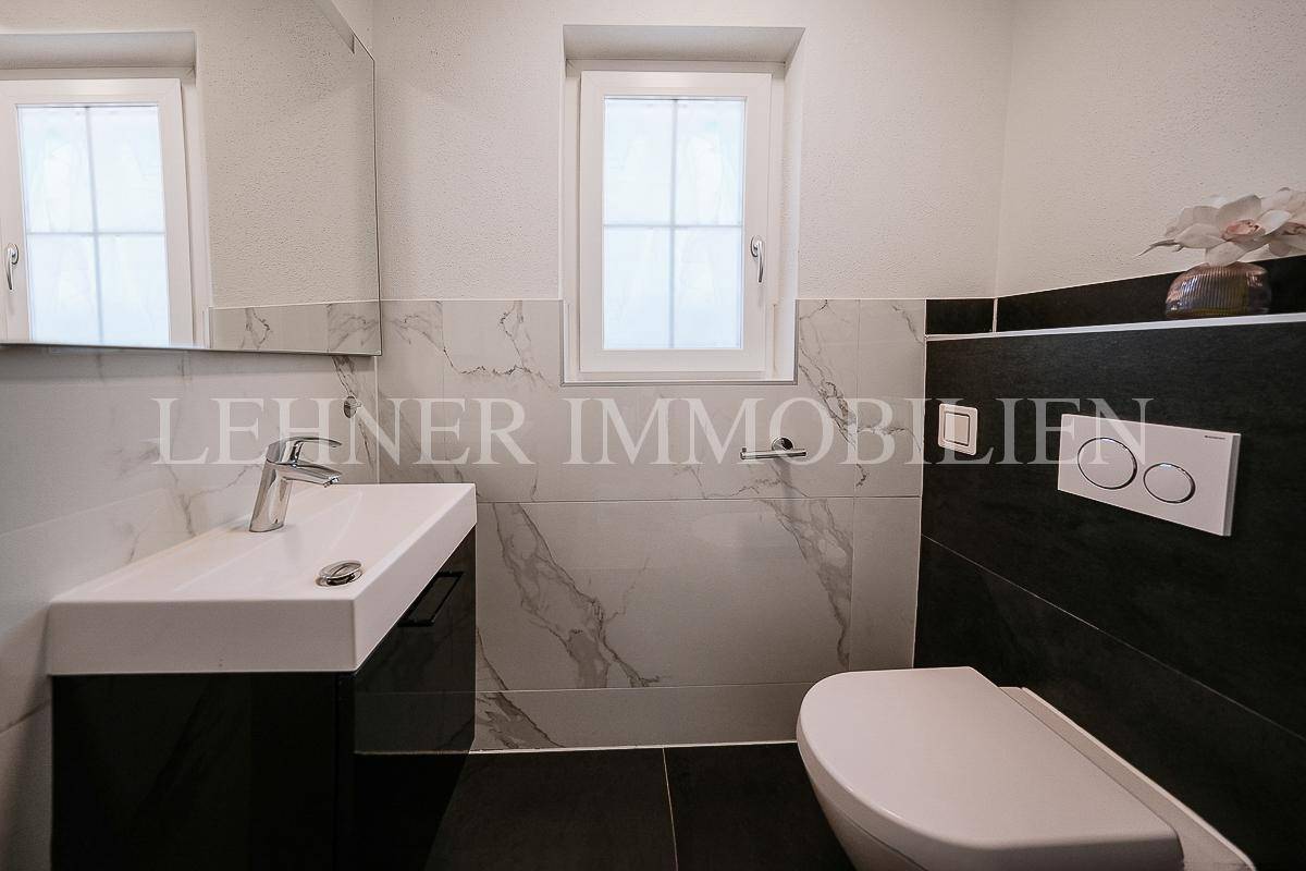 Modernes Gäste-WC mit Fenster, Wand-WC und stilvollen Fliesen.