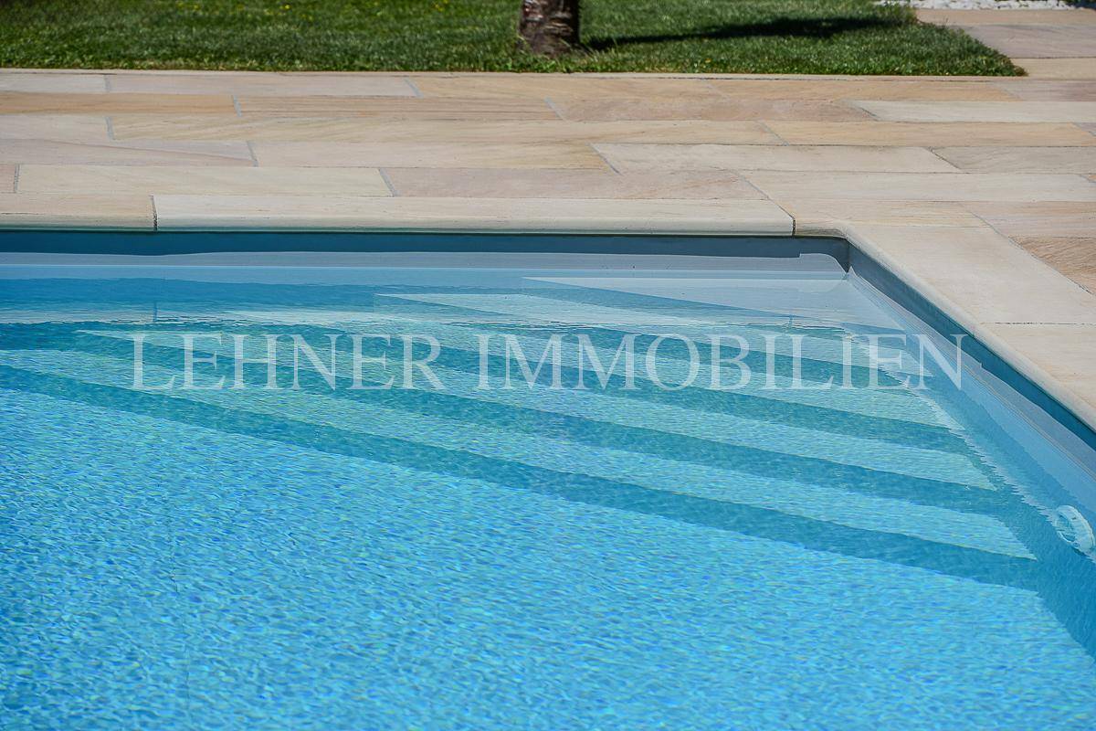 Nahaufnahme der Stufen im Pool, die einen einfachen Zugang zum kühlen Wasser ermöglichen.