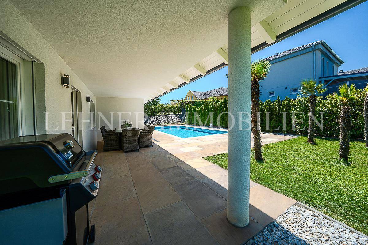 Überdachte Terrasse mit Essbereich und Grill, direkt am Pool gelegen, ideal für Sommertage.