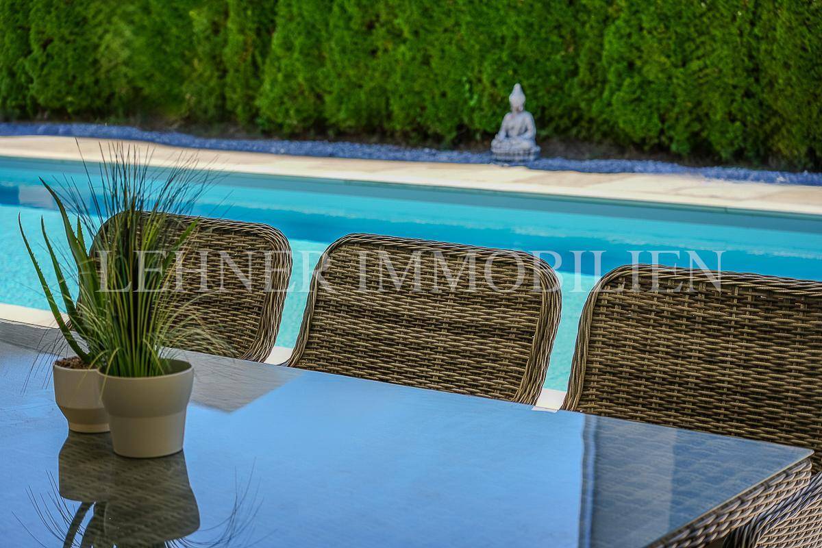 Detailaufnahme des Esstisches auf der Terrasse mit Blick auf den erfrischenden Pool.