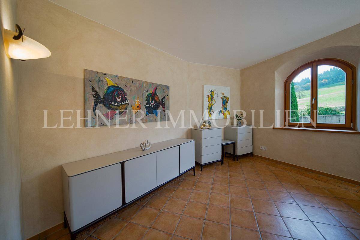 Schlafzimmer mit modernen Sideboards, Kunstwerken und einem Bogenfenster mit Ausblick.