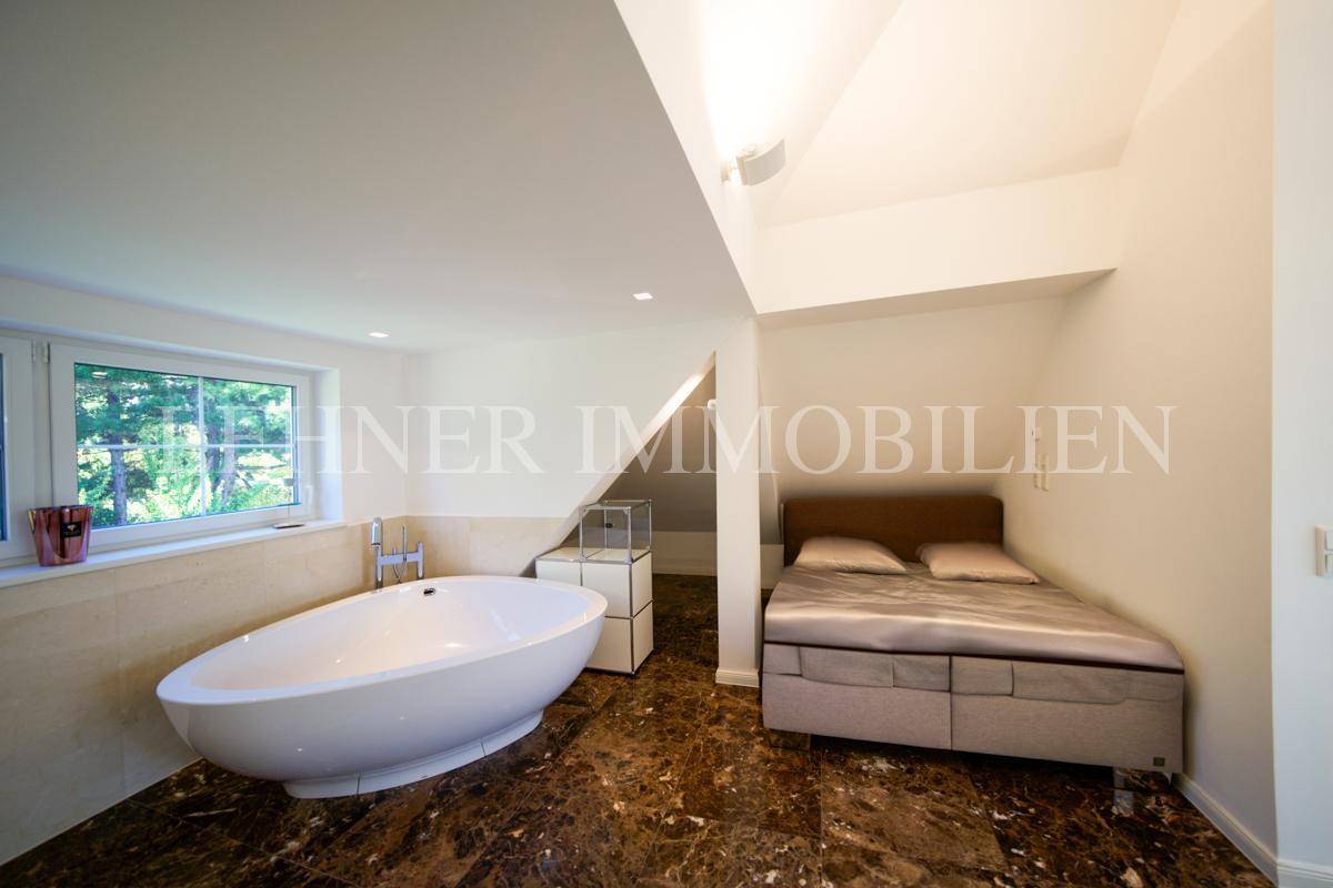 Schlafzimmer mit integrierter Badewanne und Dachschräge, bietet eine einzigartige Wohnatmosphäre.