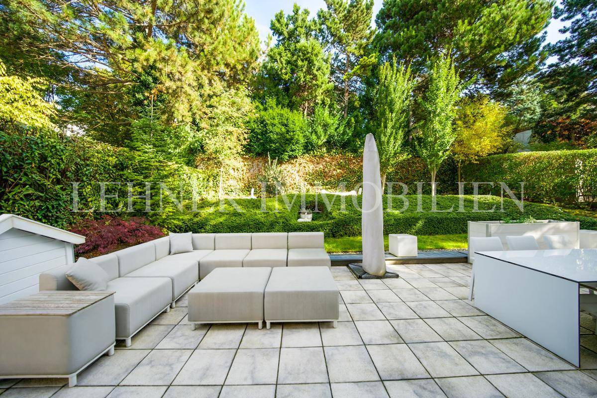 Geräumige Terrasse mit modernen Lounge-Möbeln und Essbereich, ideal für Entspannung im Freien.