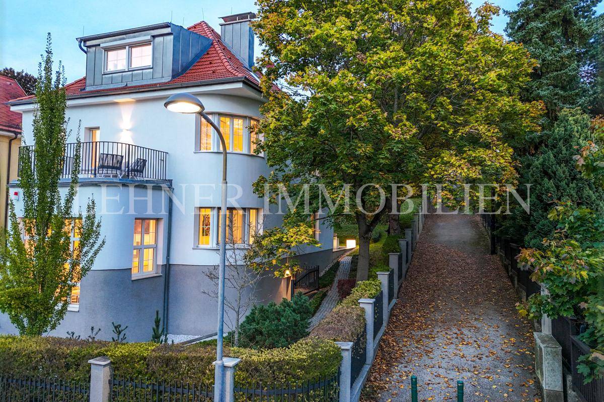Seitliche Ansicht der Stadtvilla mit einem malerischen Weg, der den Hügel hinaufführt.