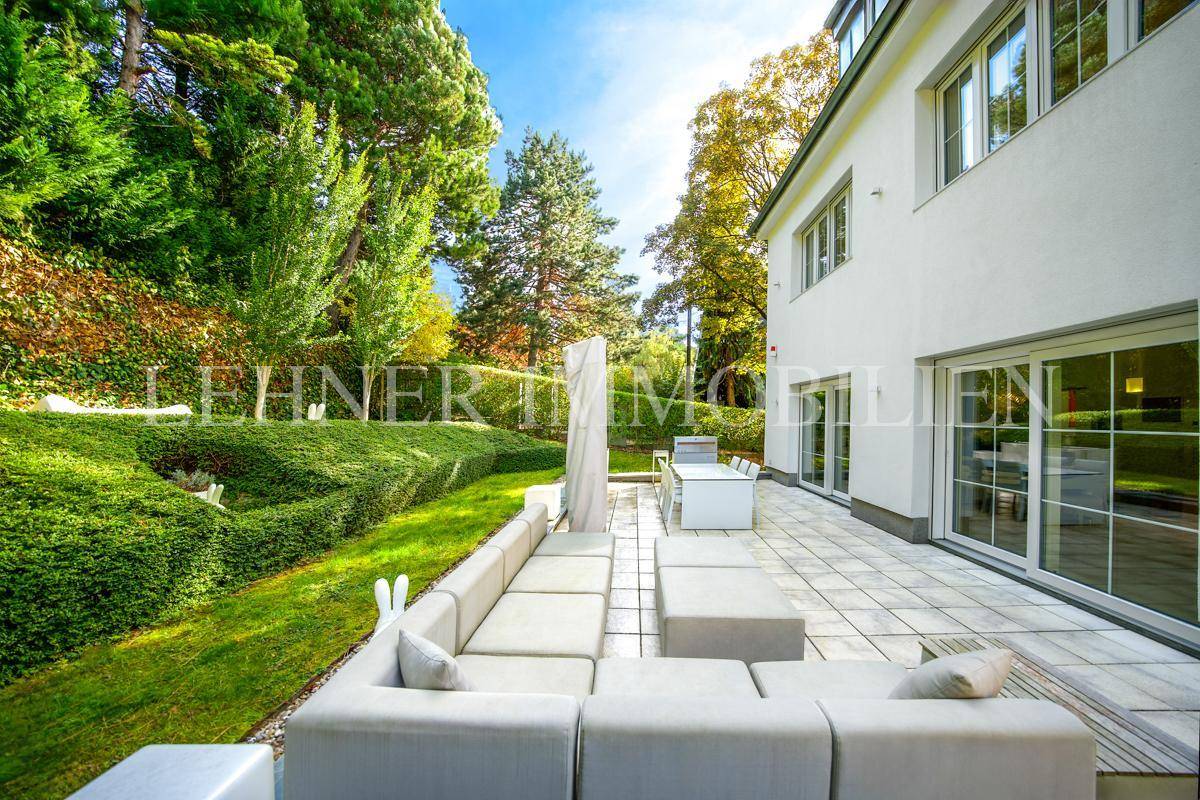 Großzügige Terrasse mit Lounge-Möbeln und Essbereich, umgeben von gepflegtem Grün.