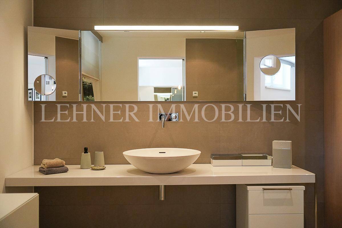 Moderner Waschtisch mit Aufsatzwaschbecken und dreiteiligem Spiegelschrank im Badezimmer.