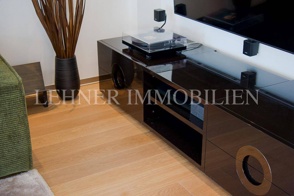 Elegantes schwarzes TV-Möbel mit Plattenspieler auf hellem Holzfußboden im Wohnbereich.
