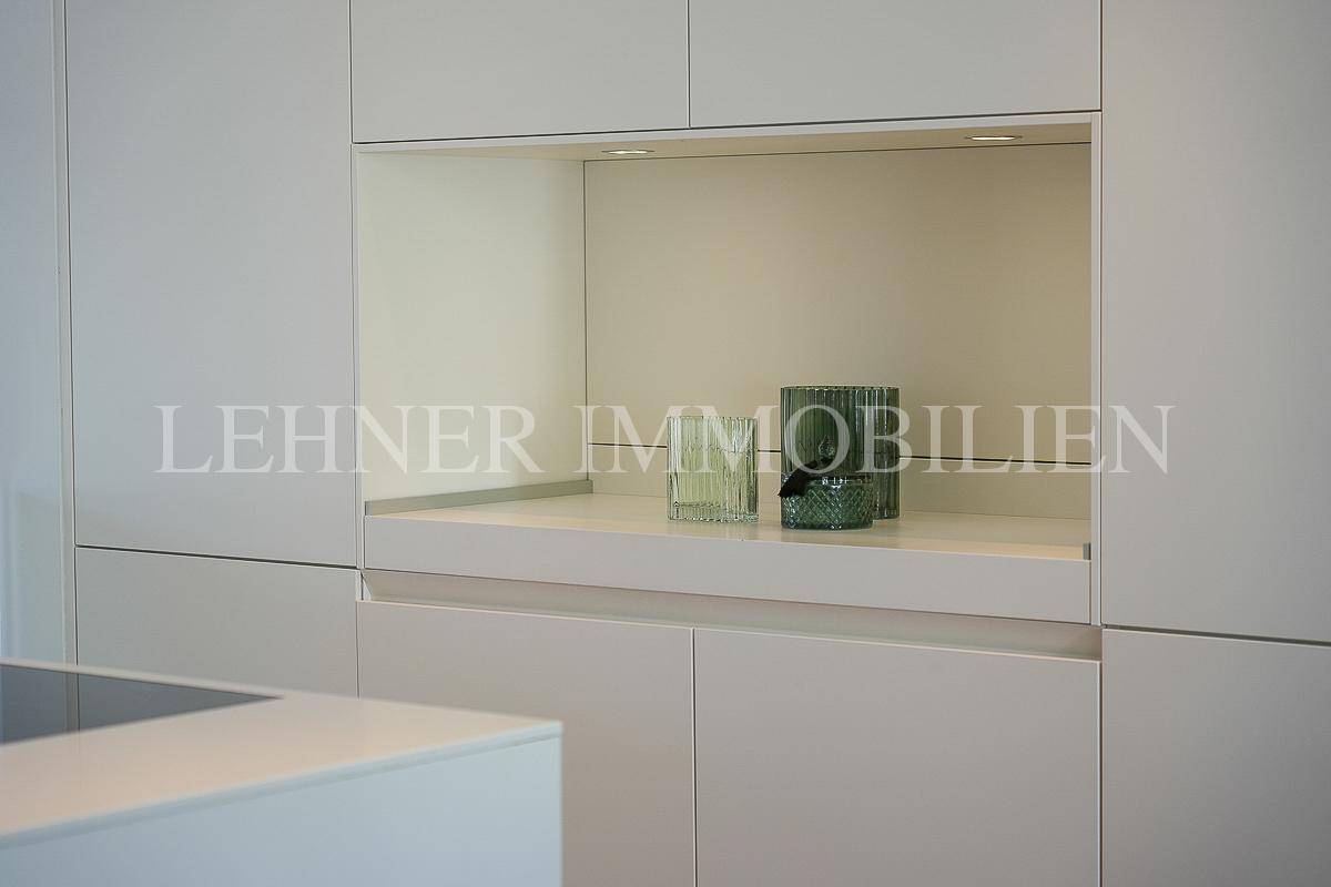 Detailaufnahme der Kücheninsel mit Spülbecken, modernem Wasserhahn und Induktionskochfeld.