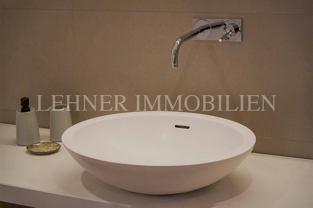 Nahaufnahme eines eleganten Aufsatzwaschbeckens mit Wandarmatur in modernem Design.