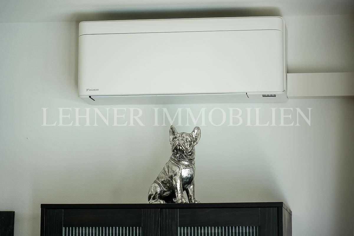 Klimaanlage an der Wand über einem Schrank mit dekorativer Skulptur.