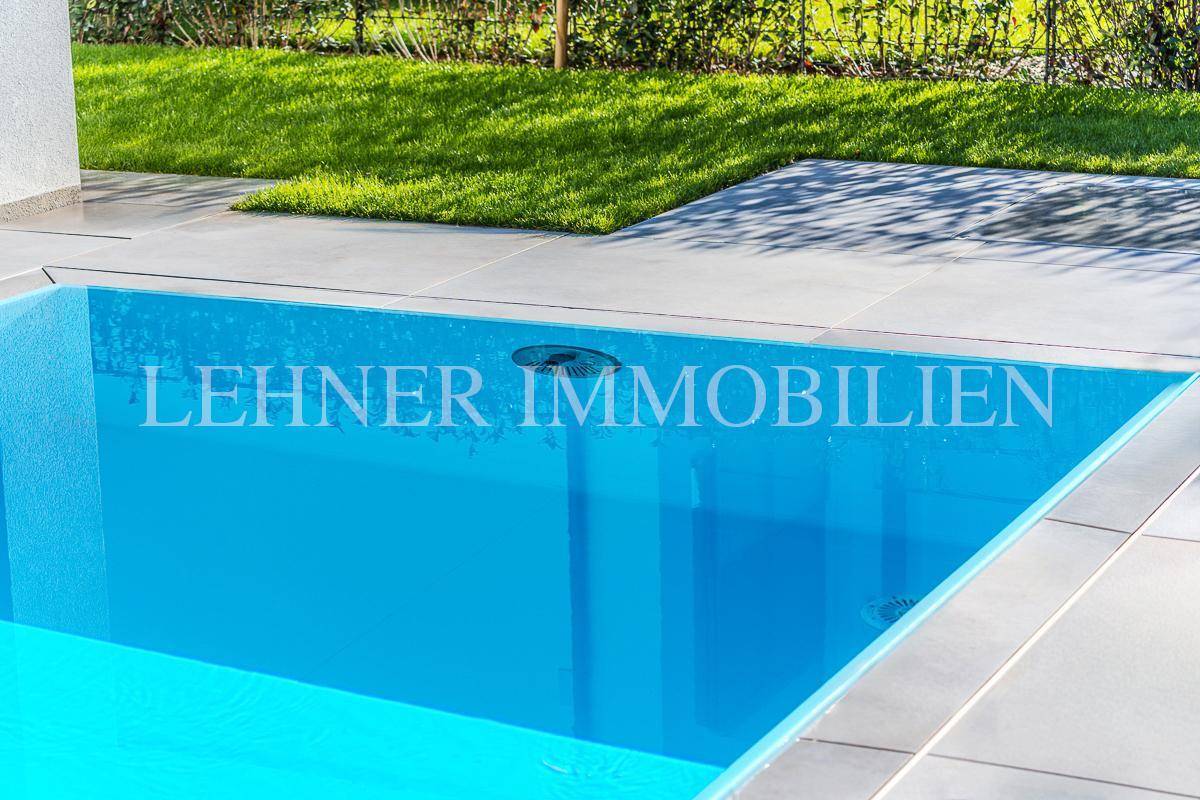 Detailaufnahme des Pools mit klarem, blauem Wasser und modernem Fliesenrand.