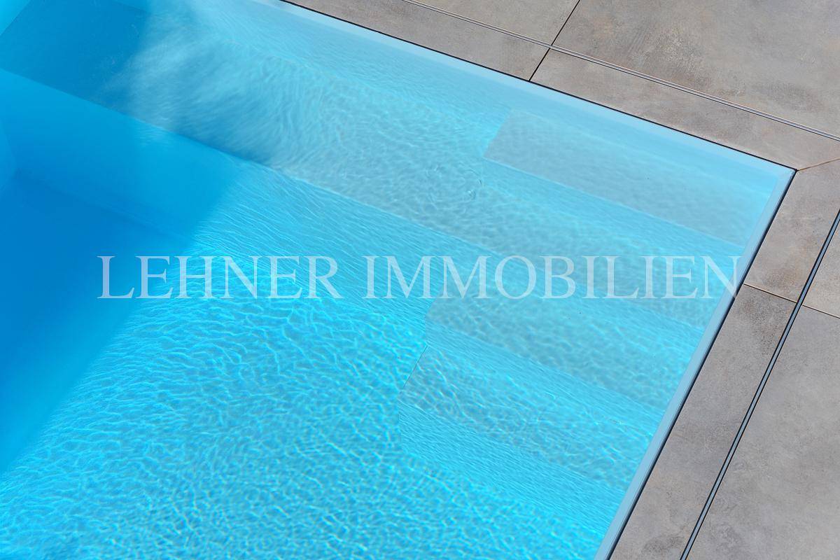 Stufen im Pool mit hellblauem Wasser und sauberem, modernem Design.