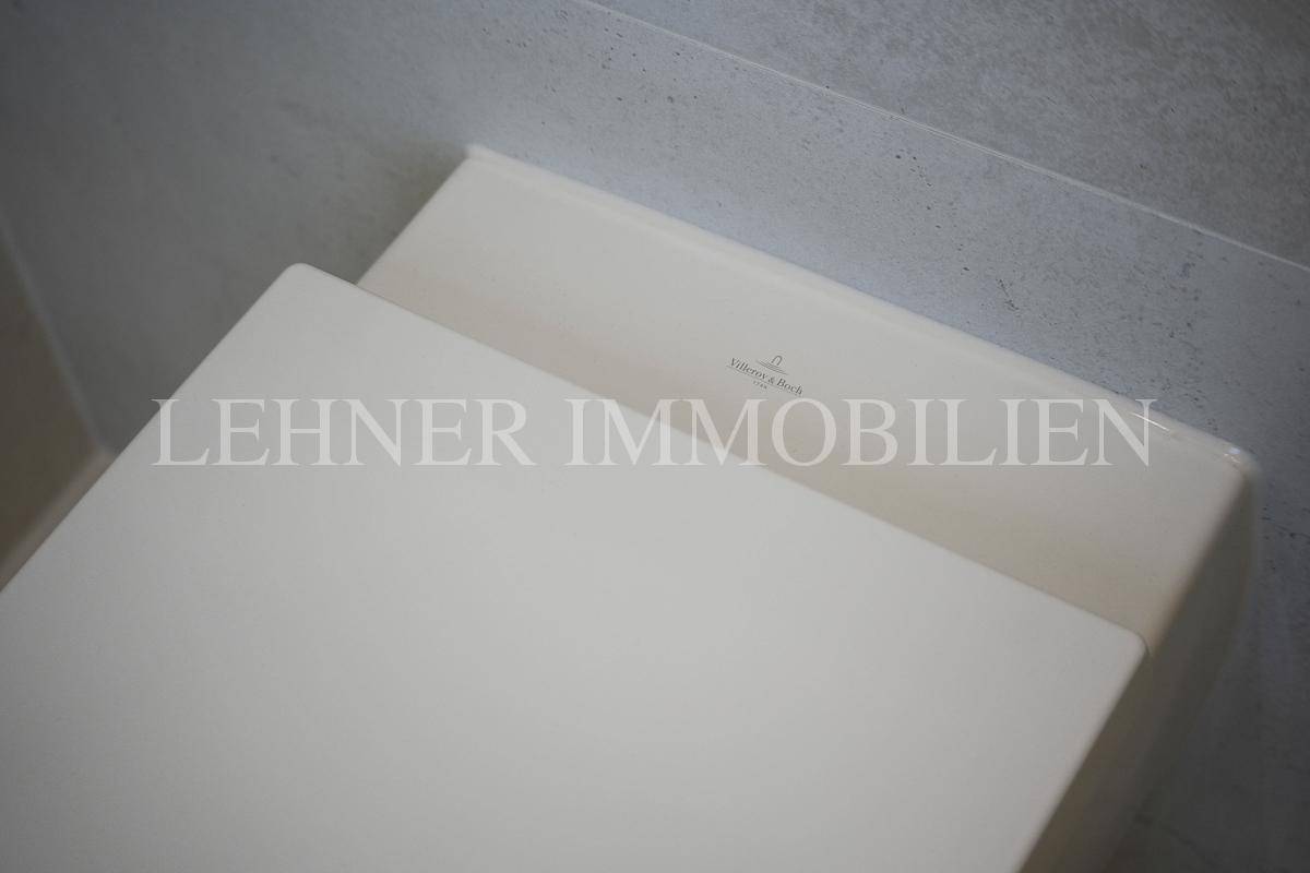 Nahaufnahme eines modernen Wand-WCs mit minimalistischem Design und weißer Keramik.