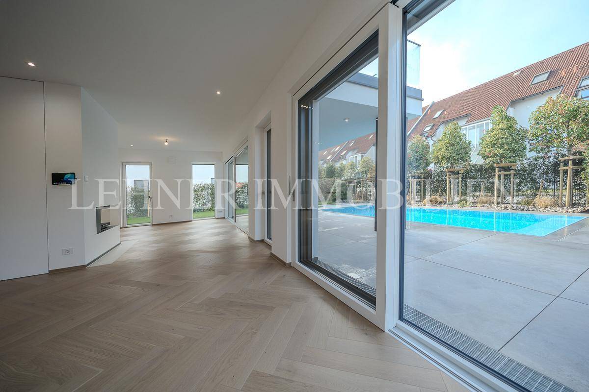 Heller Wohnbereich mit großen Schiebetüren, die direkten Zugang zum Pool und zur Terrasse bieten.