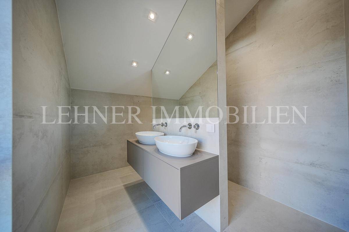 Modernes Badezimmer mit Doppelwaschbecken, großem Spiegel und hellen Fliesen.
