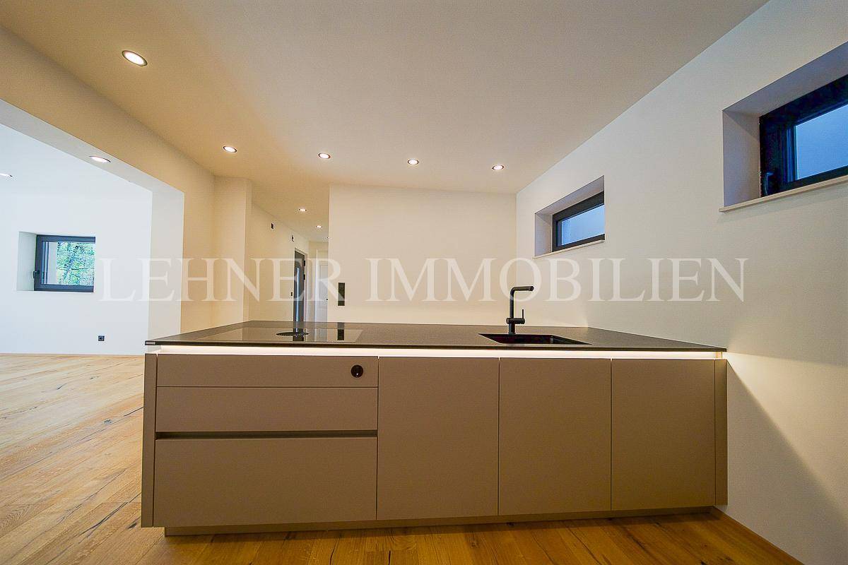 Geräumige Küche mit großer Kücheninsel und Blick in den offenen Wohnbereich, modern und hell.
