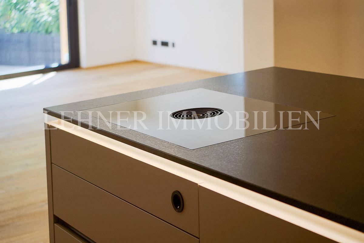 Detailansicht des integrierten Induktionskochfeldes auf der Kücheninsel, modern und minimalistisch.