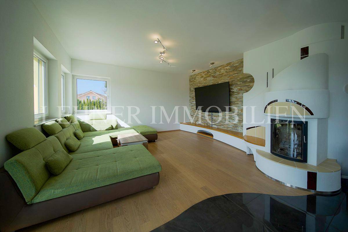 Gemütliches Wohnzimmer mit großem Sofa, Kamin und Steinwandakzent.