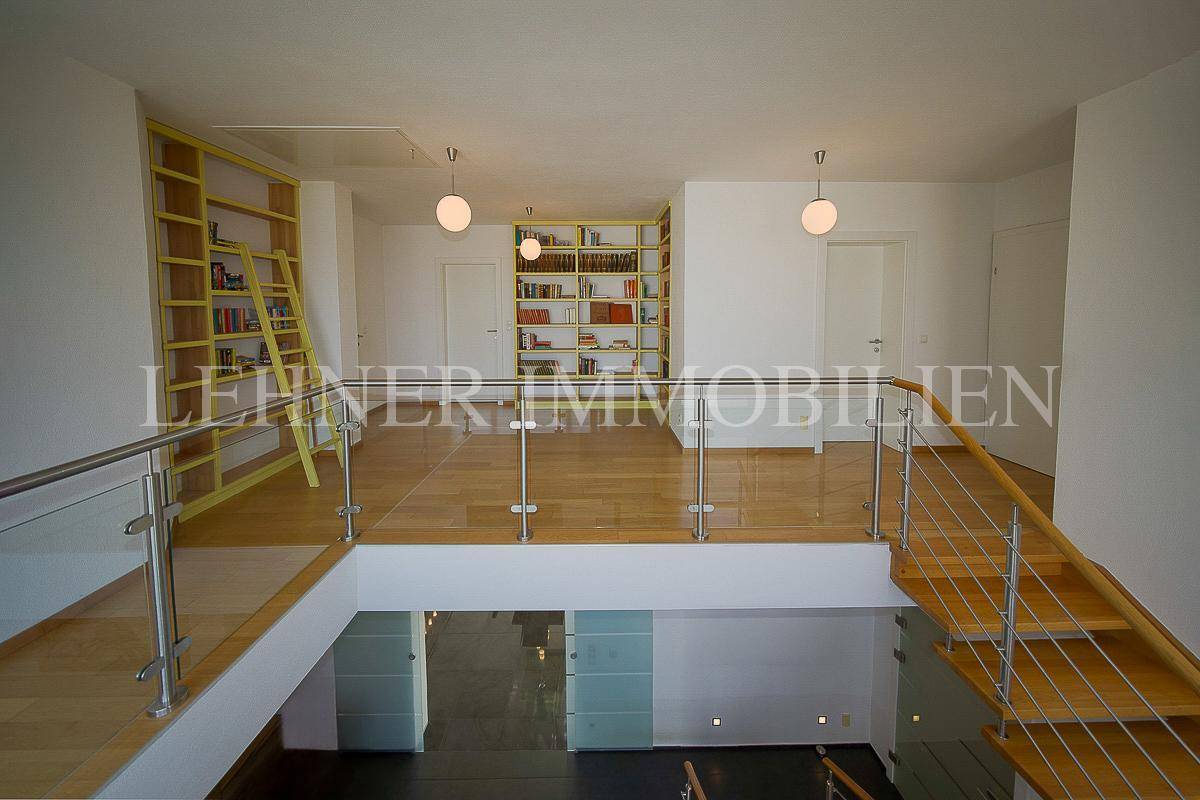 Heller Flur im Obergeschoss mit Holzfußboden und integrierten Bücherregalen.