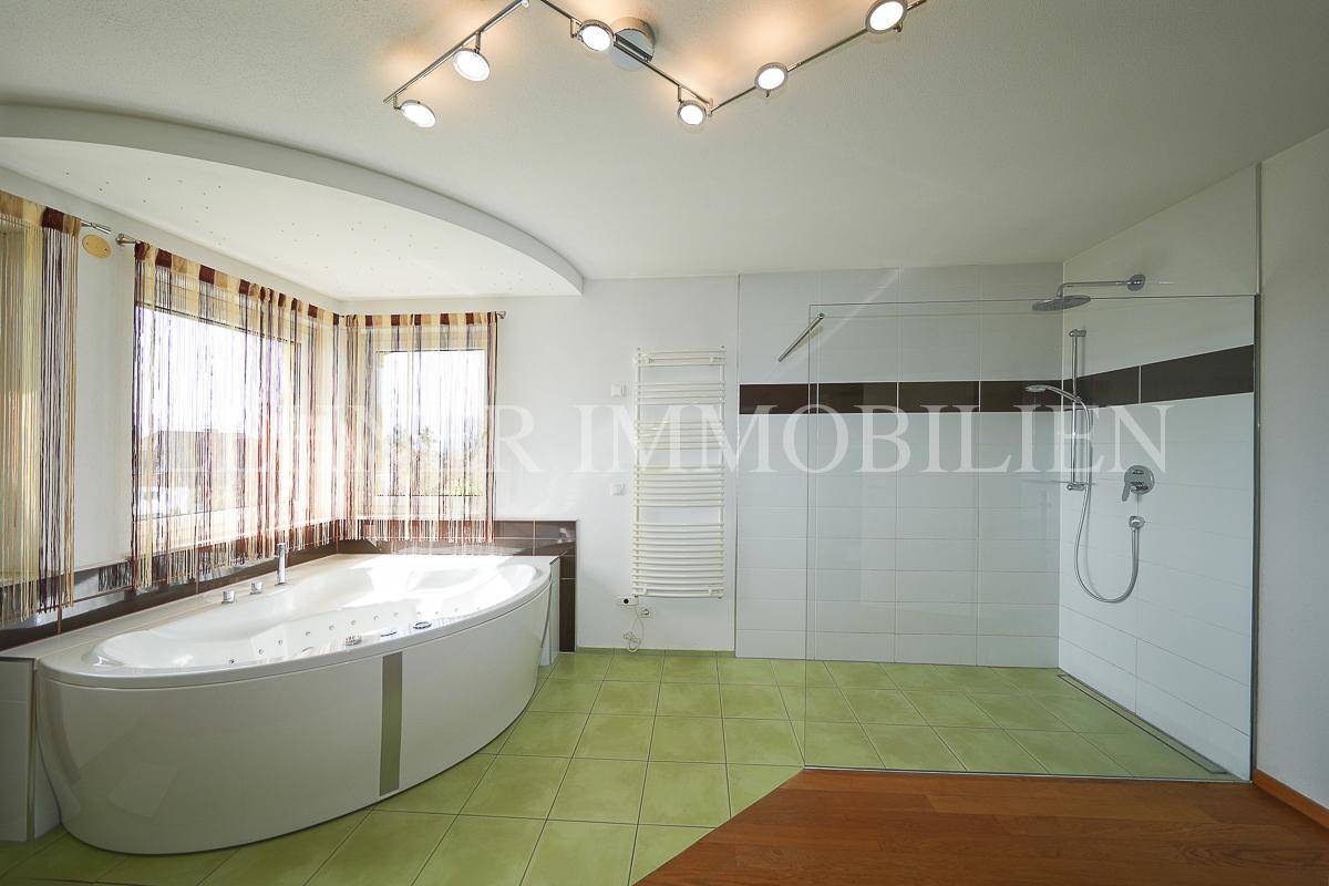Modernes Badezimmer mit großer Whirlpool-Badewanne und geräumiger Duschkabine.