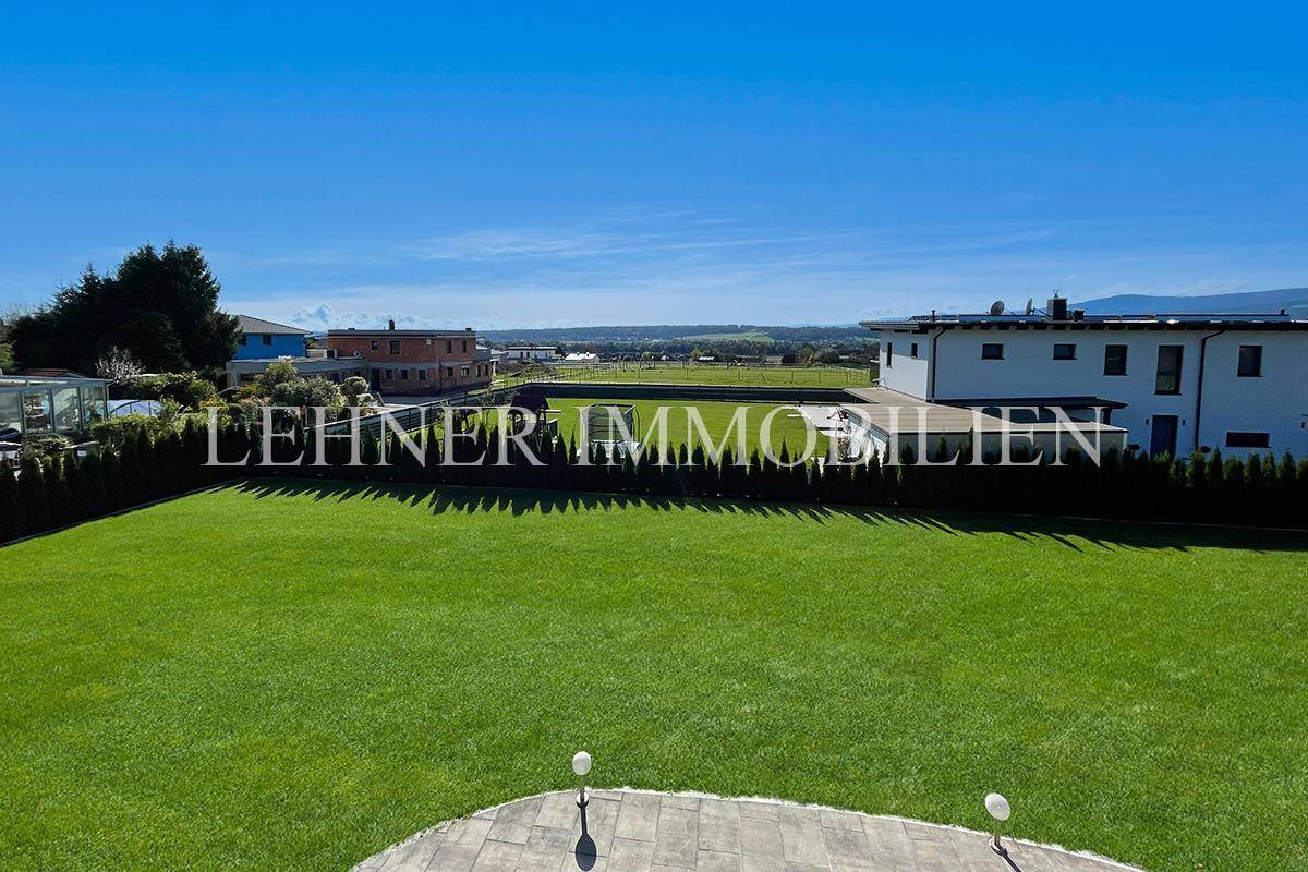 Weitläufiger Gartenbereich mit gepflegtem Rasen und Panoramablick in die Ferne.