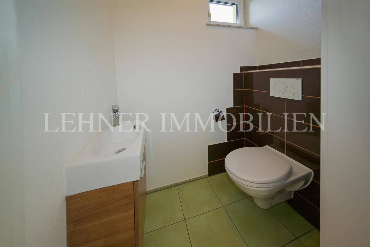Kleines Gäste-WC mit modernem Waschbecken und Wand-WC.