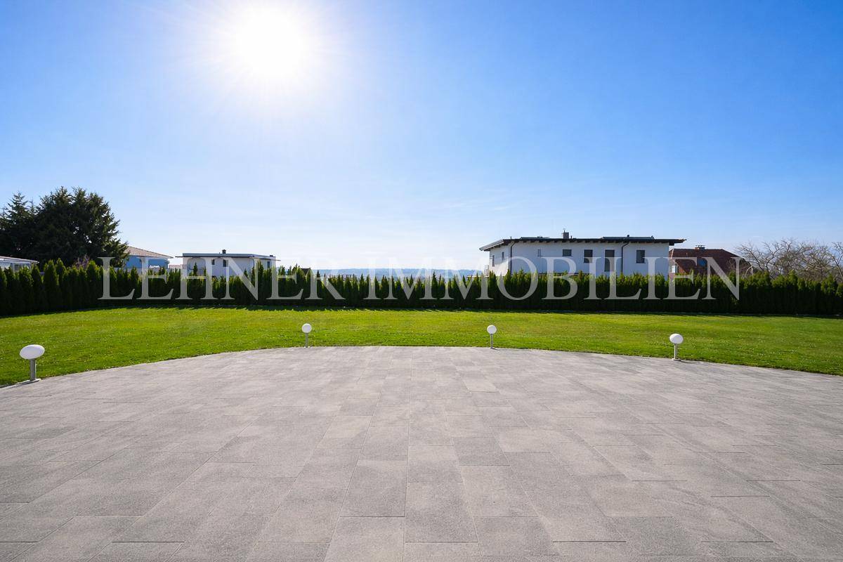 Große gepflasterte Terrasse mit weitem Blick über die grüne Landschaft.