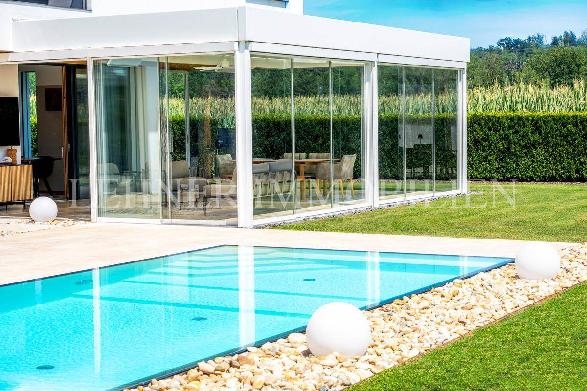 Moderner Swimmingpool im Gartenbereich mit Kiesbett und Rasenfläche.