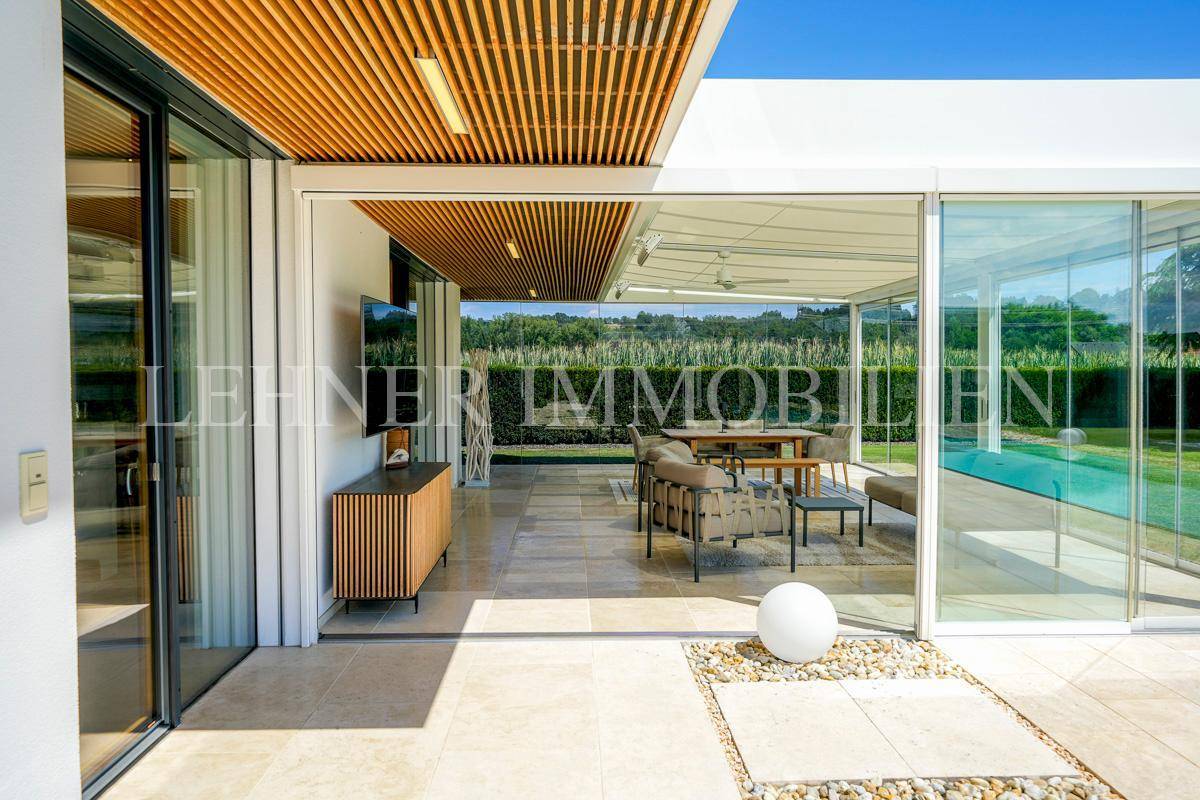 Terrasse mit Zugang zum Wintergarten und Blick auf den Swimmingpool.
