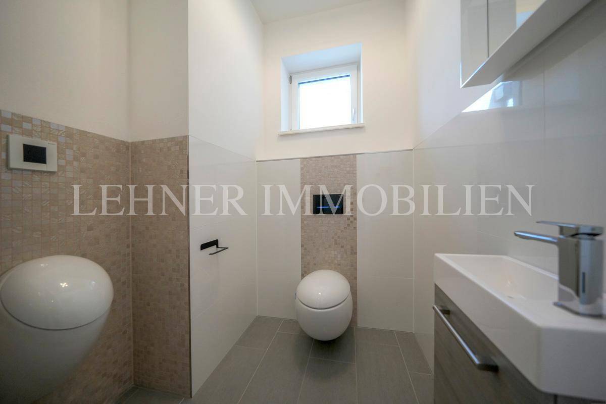 Modernes Gäste-WC mit Wand-WC, Urinal, kleinem Waschbecken und Fenster.