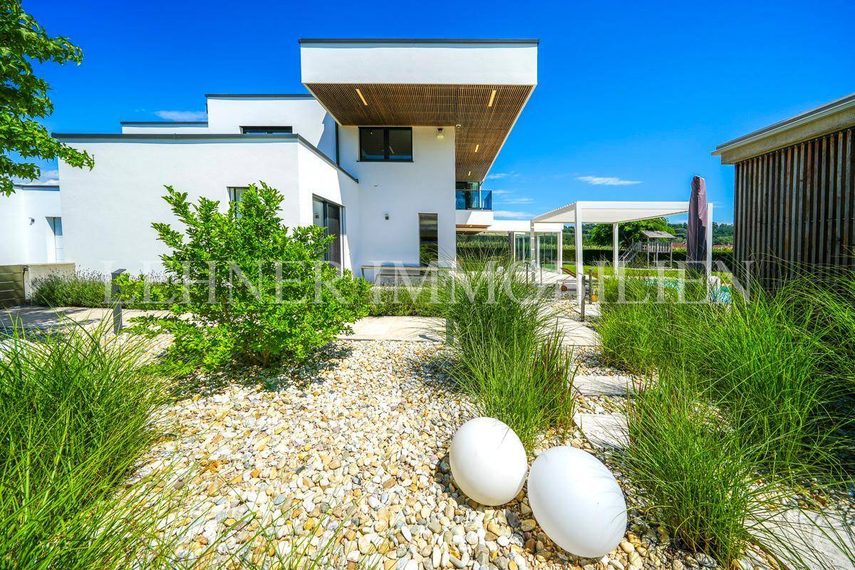 Moderne Architektur des Hauses mit minimalistischer Gartengestaltung und Kieswegen.