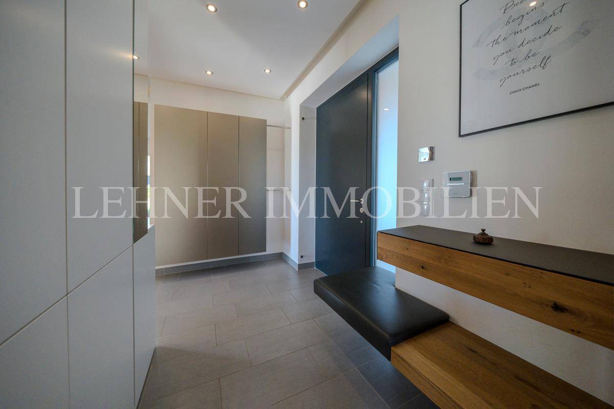 Heller Flur mit Einbaumöbeln, Sitzbank und Garderobe, ideal für den Empfang von Gästen.