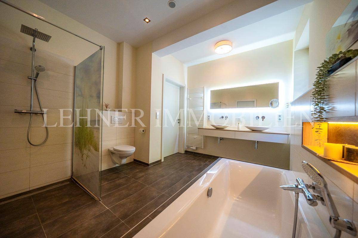 Geräumiges Badezimmer mit begehbarer Dusche, Badewanne und modernem Doppelwaschbecken.