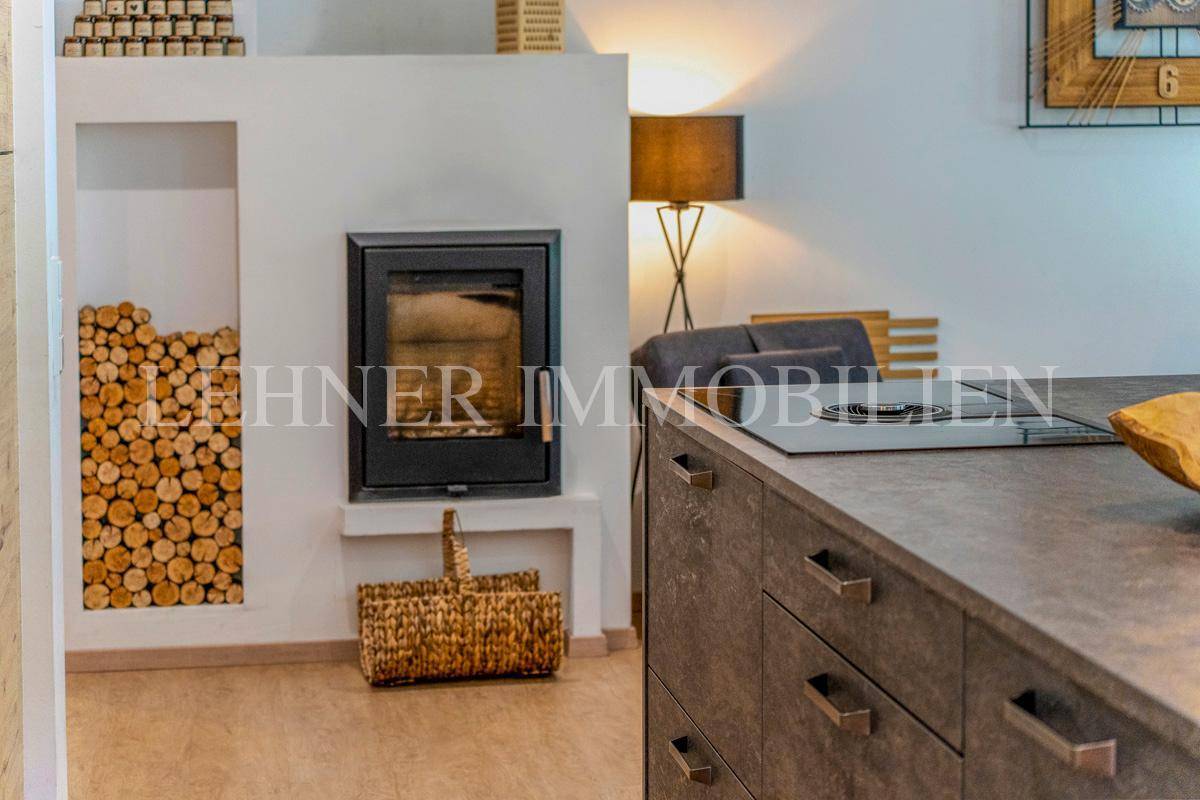 Moderner Kamin mit integrierter Holzablage, schafft eine gemütliche Atmosphäre im Wohnbereich.