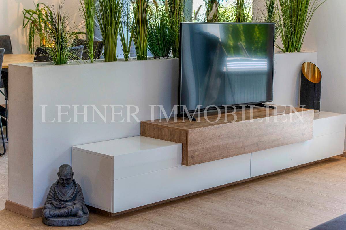 Detailansicht des modernen TV-Möbels mit Dekoration und Pflanzen im Wohnbereich.