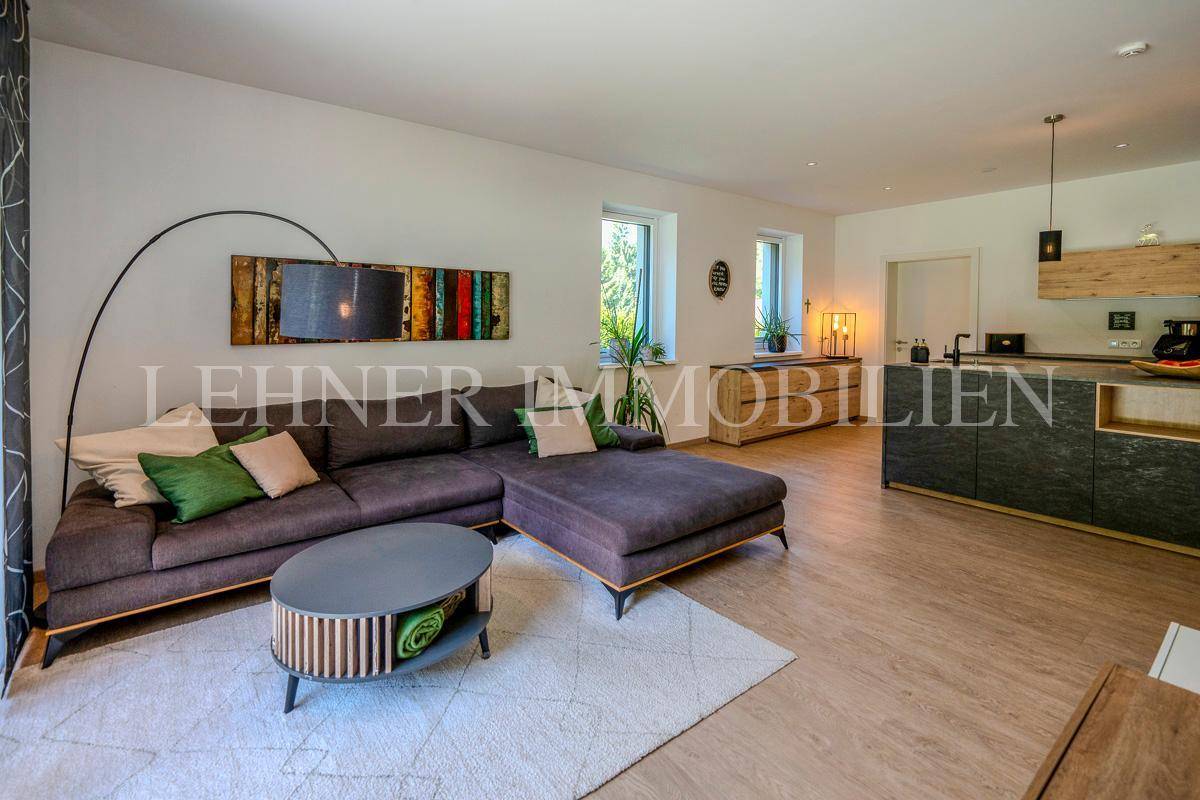 Geräumiger Wohnbereich mit großem Ecksofa, Couchtisch und Blick auf die offene Küche.