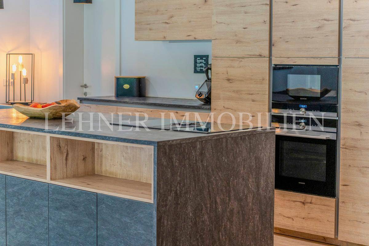 Detailansicht der modernen Küche mit Induktionskochfeld und Holzschränken.