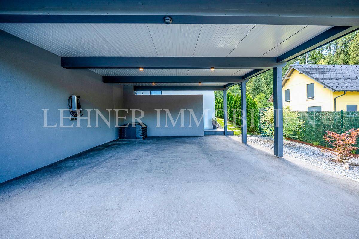 Geräumiger Carport mit Beleuchtung und Zugang zum Hauseingang.