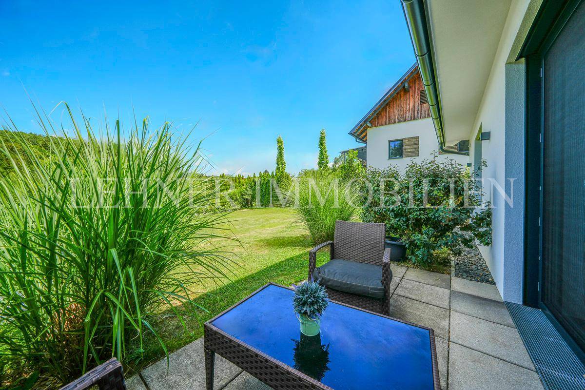 Gemütliche Terrasse mit Gartenmöbeln und Blick auf den grünen Garten.