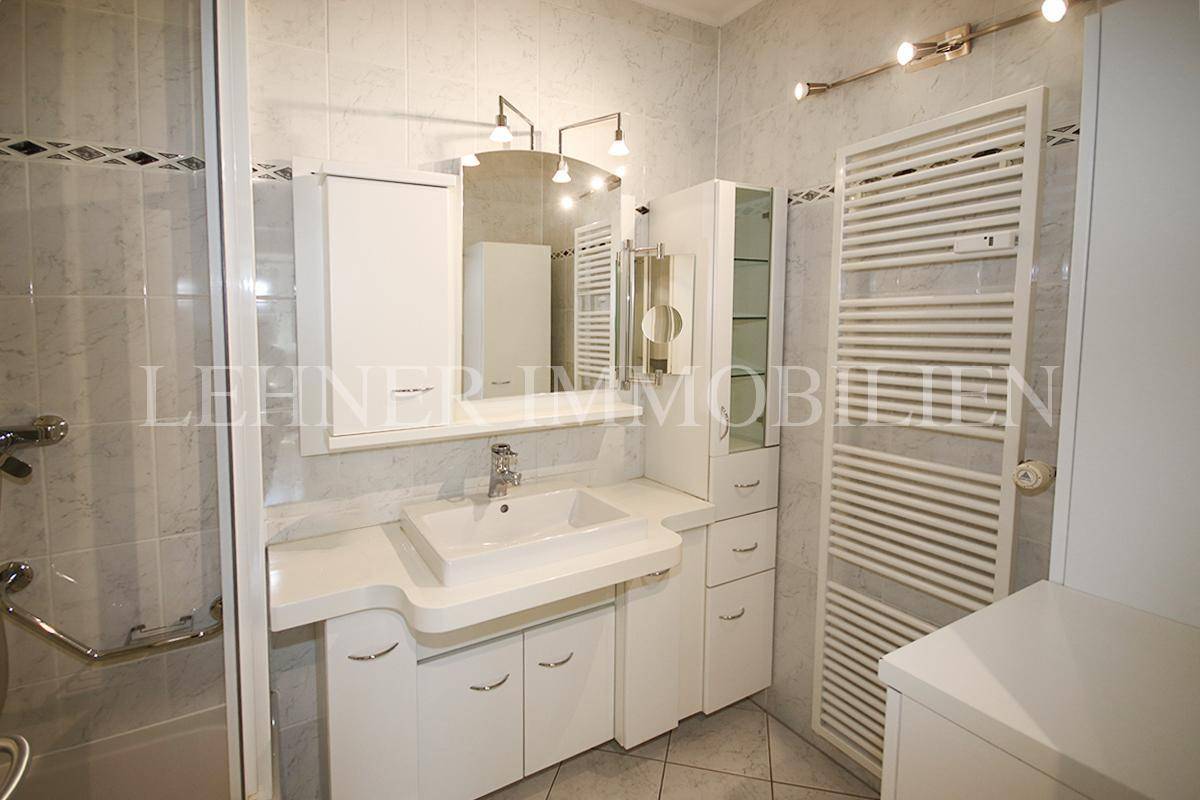 Modernes Badezimmer mit Waschtisch, Spiegelschrank und beheiztem Handtuchhalter.