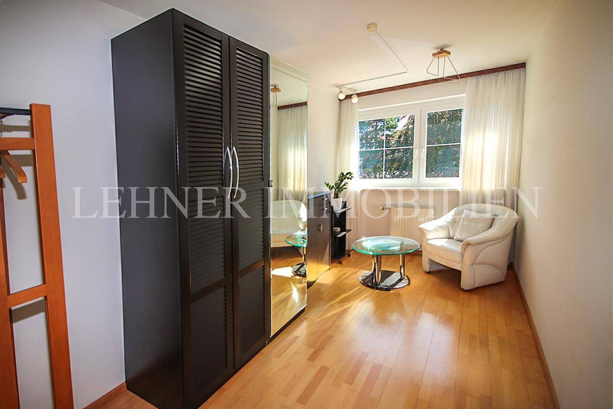Weiteres Schlafzimmer mit Kleiderschrank, Sessel und Fenster, ideal als Gästezimmer.