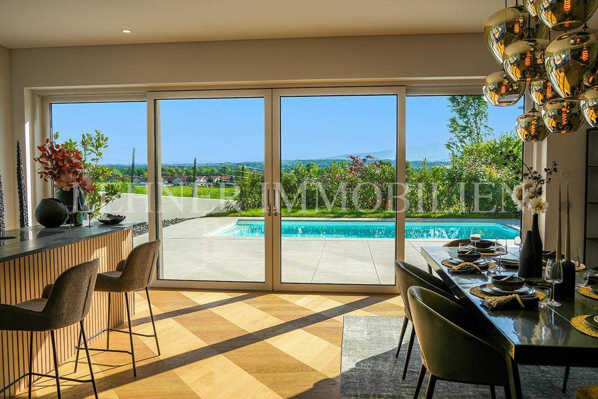 Heller Essbereich mit Holzboden und großzügiger Glasfront, die den Blick auf den Pool freigibt.