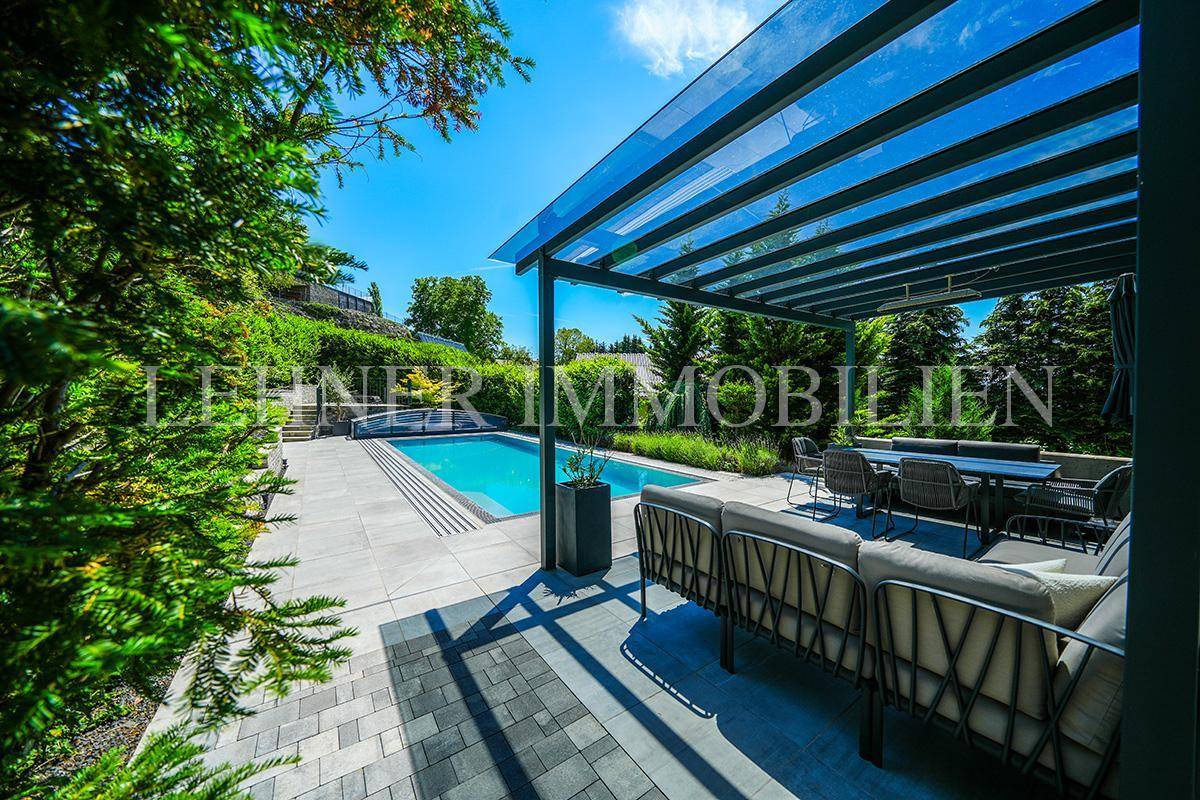 Weitläufige Terrasse mit modernen Outdoor-Möbeln und direktem Zugang zum Swimmingpool.