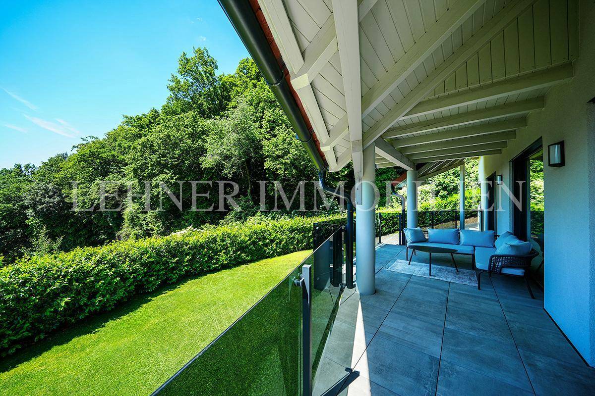 Überdachte Terrasse mit bequemen Gartenmöbeln und weitem Blick ins Grüne.